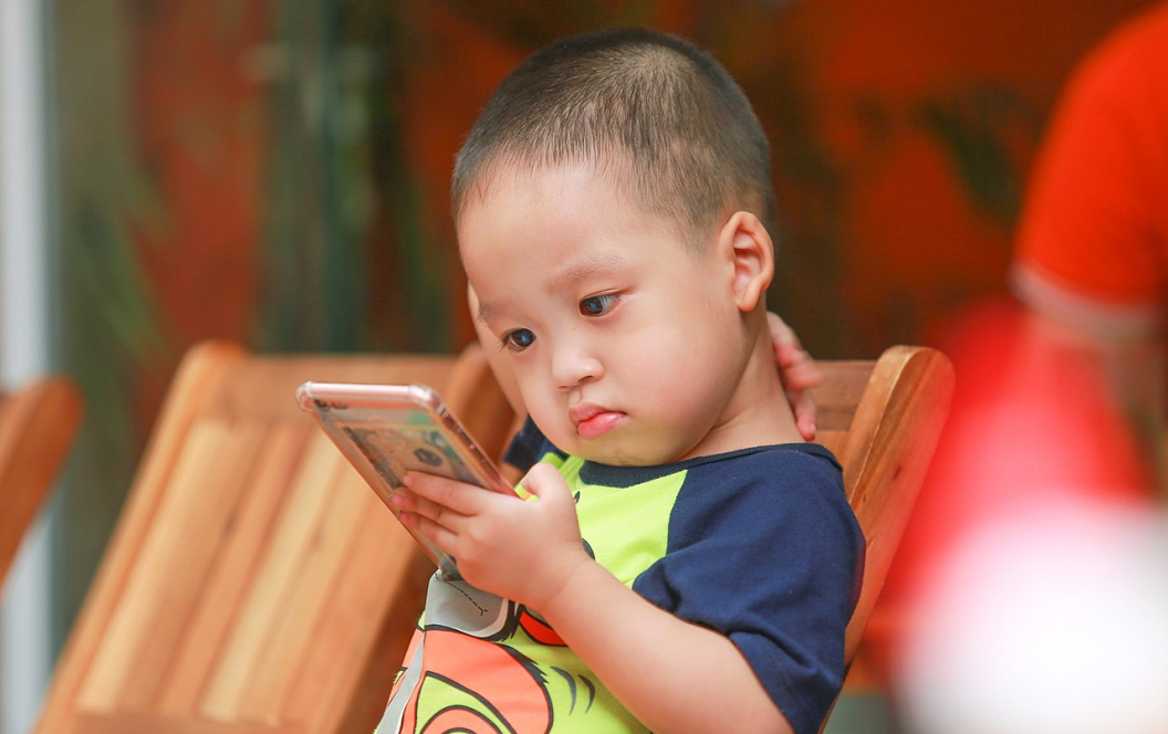 Fotografía de un niño con un smartphone (Foto: Kaku Nguyen)